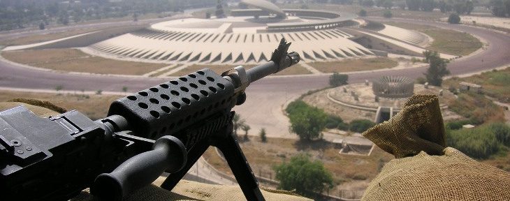 An Iraqi machine gun sits ominously in the foreground, pointing out towards an official Iraqi building
