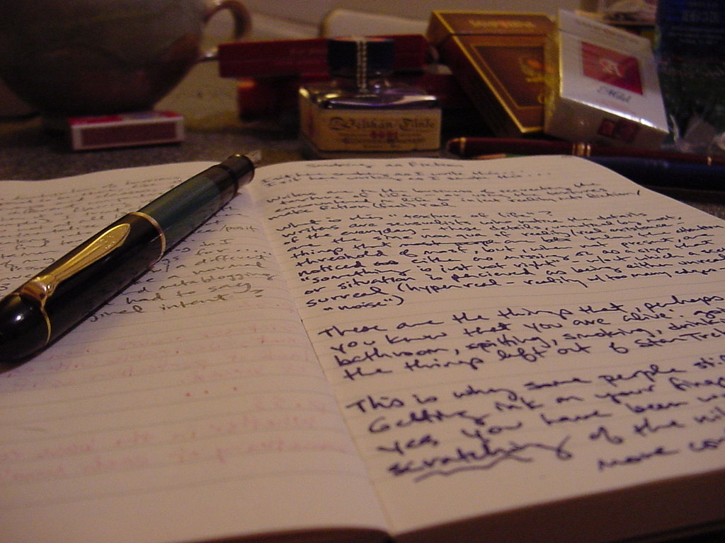 fountain pen and writing pad covered in notes