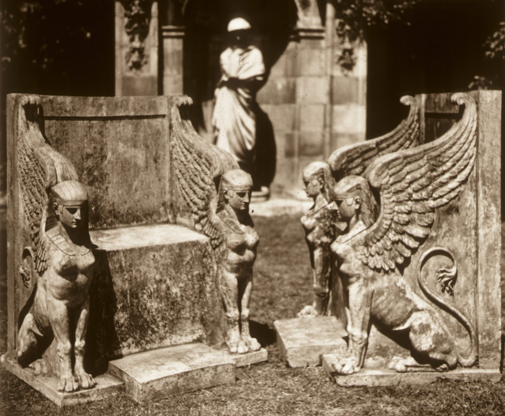 Photo showing four small sphinx like creatures carved in stone.