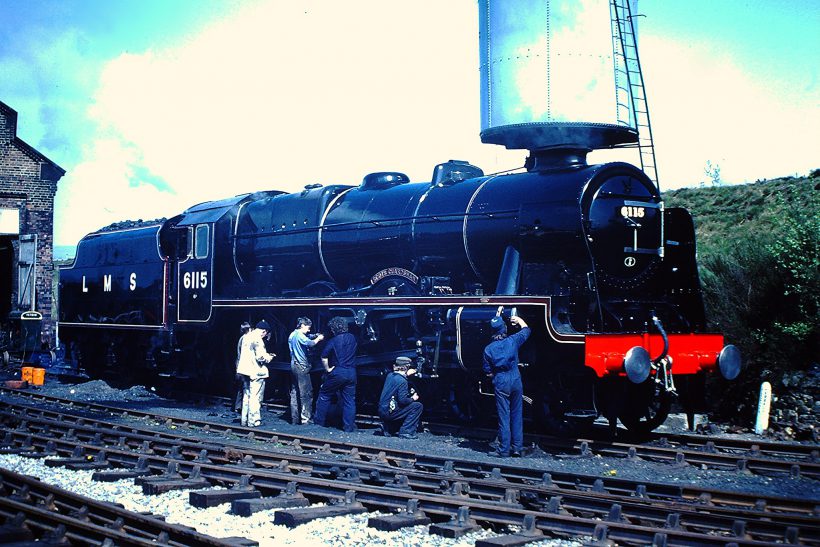 The locomotive ‘Scots Guardsman' (built by North British works No.23610 in 1927, rebuilt Crewe 1947) in 1946 LMS lined black livery at the Dinting Railway Centre, April 1980. Six men stand alongside, working on the engine.
